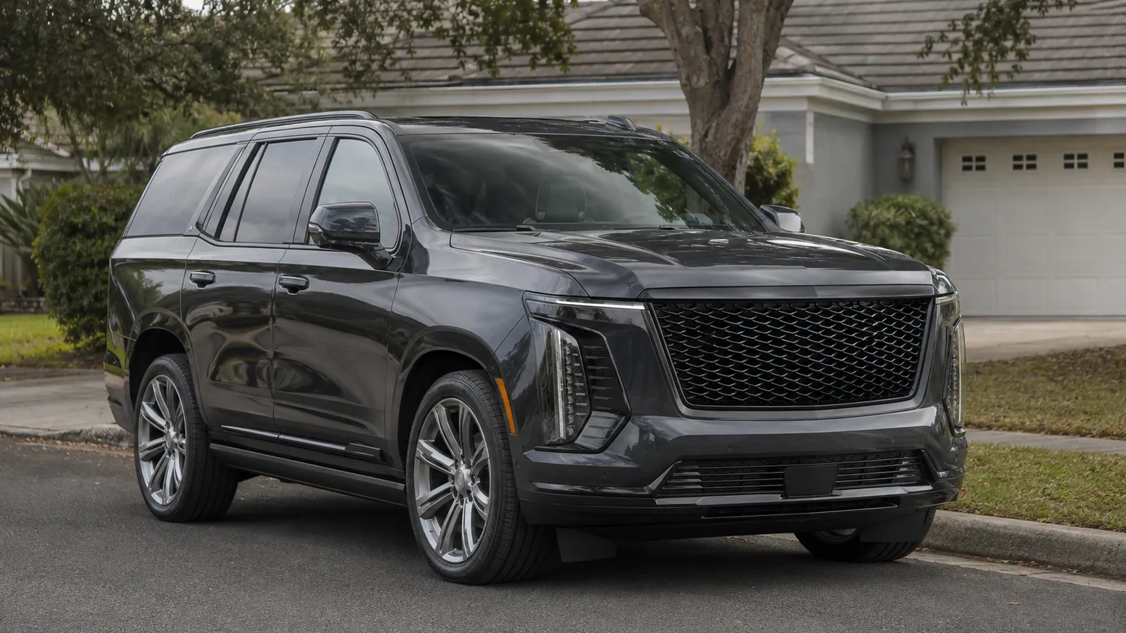 2026 Cadillac Escalade parked at the kerb on a suburban street, seen from the front three-quarter - Cadillac Escalade