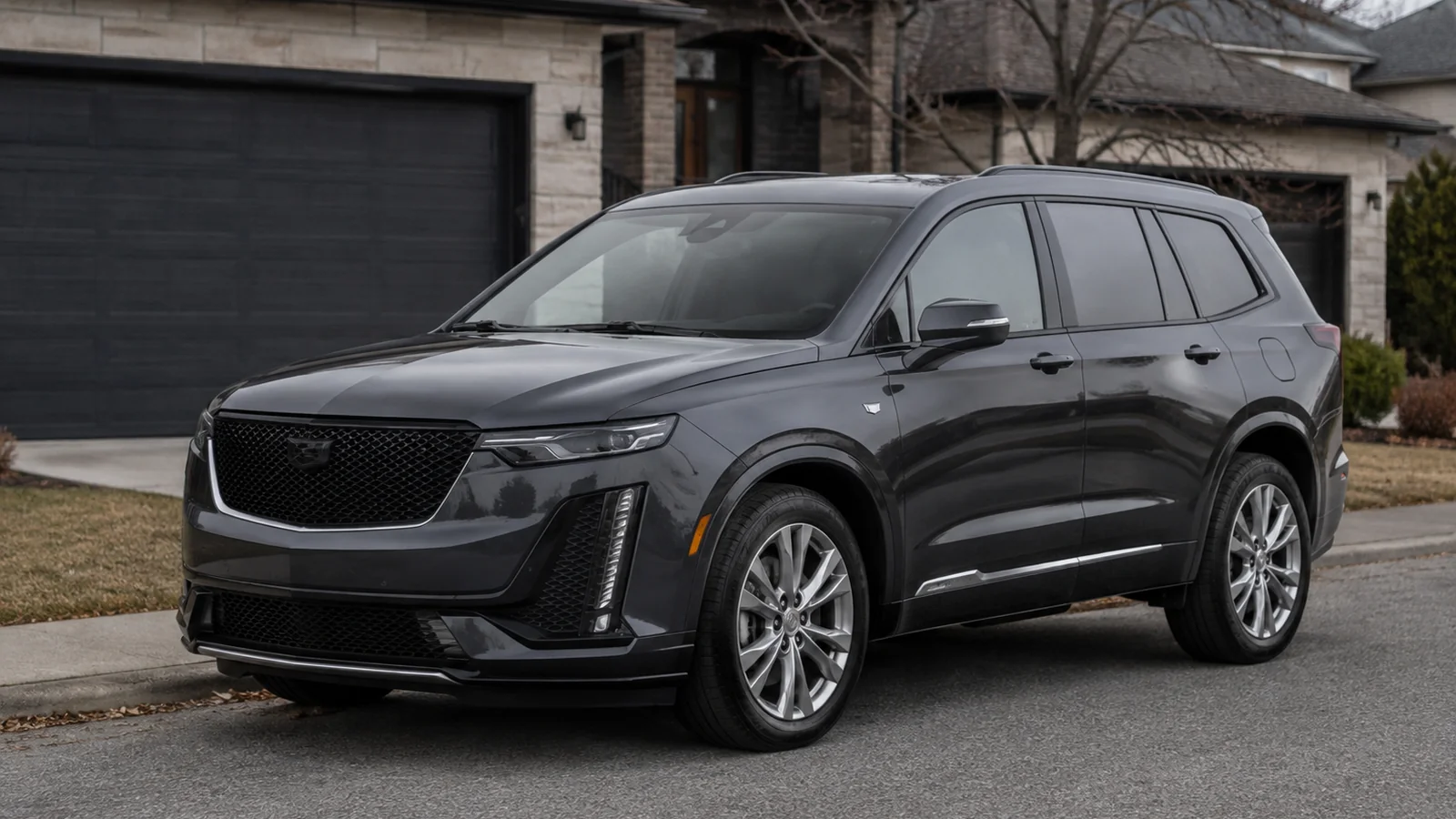 2025 Cadillac XT6 parked at the kerb on a suburban street, seen from the front three-quarter - Cadillac XT6