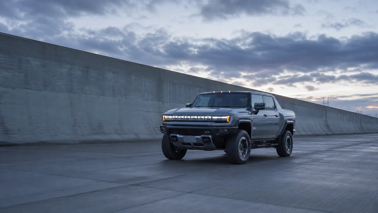 2026 GMC Hummer EV Pickup on a concrete flood-control road at dawn