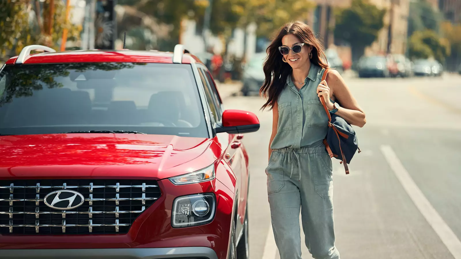 Red Hyundai Venue parked at the curb as its driver approaches - Hyundai Venue