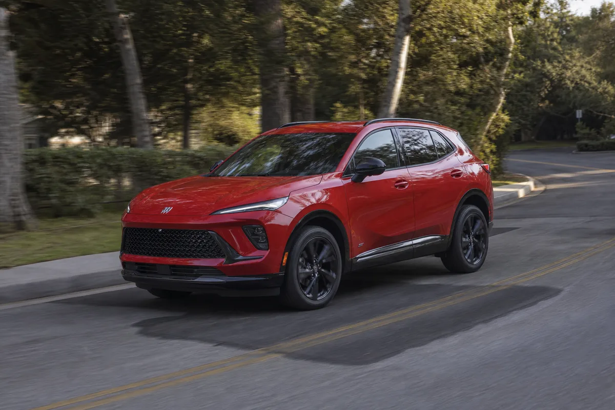 Red 2026 Buick Envision Sport Touring on a patched suburban bend