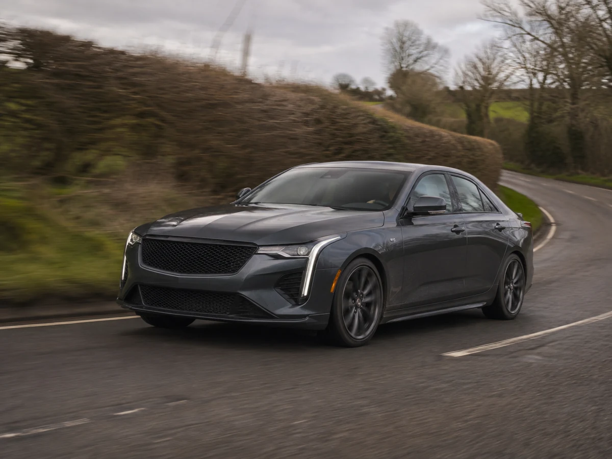 Cadillac CT4 cornering on a patched two-lane road, seen low from the front three-quarter - Cadillac CT4
