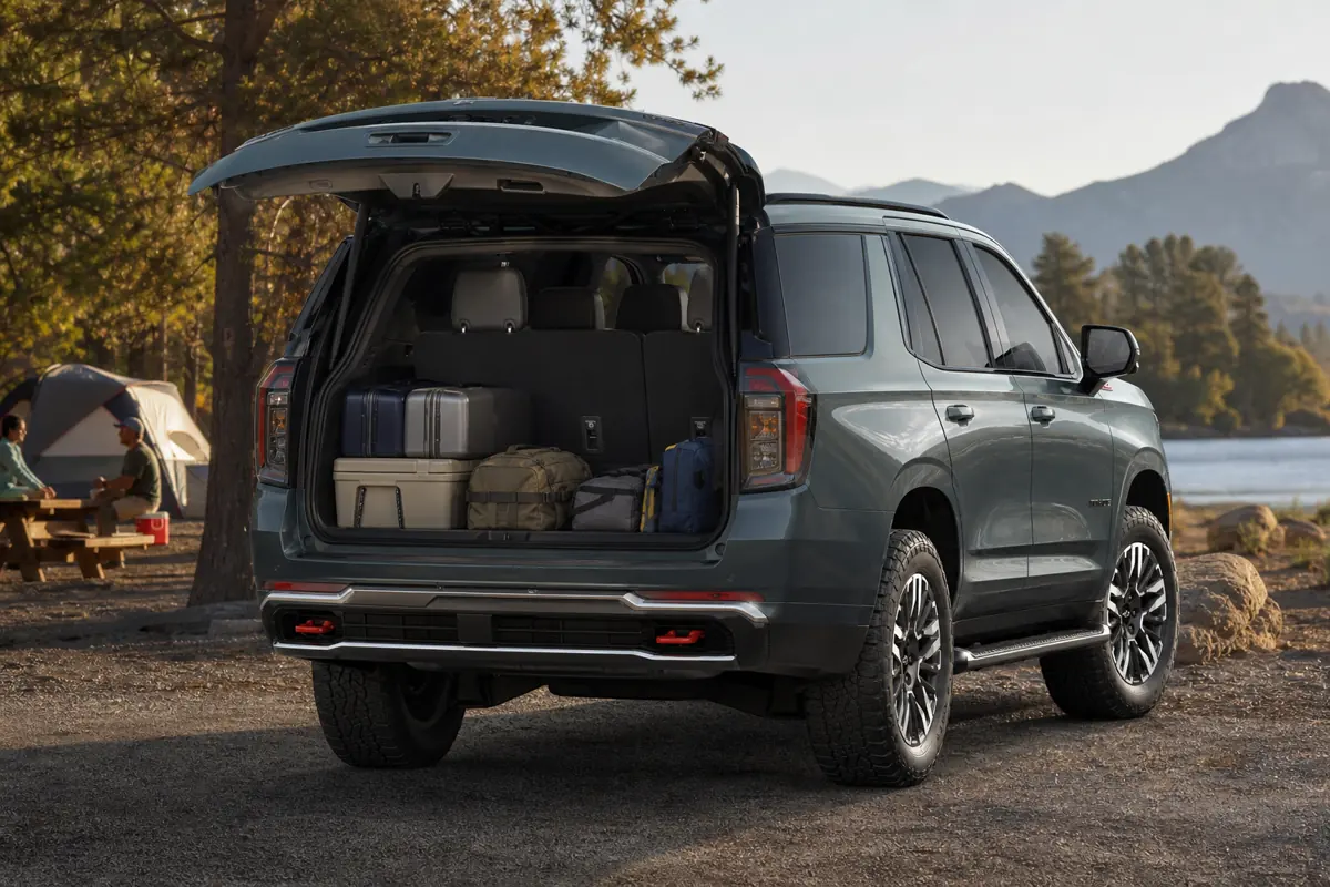 Chevrolet Tahoe with three-row seating raised while family suitcases and a stroller are test-fitted behind it