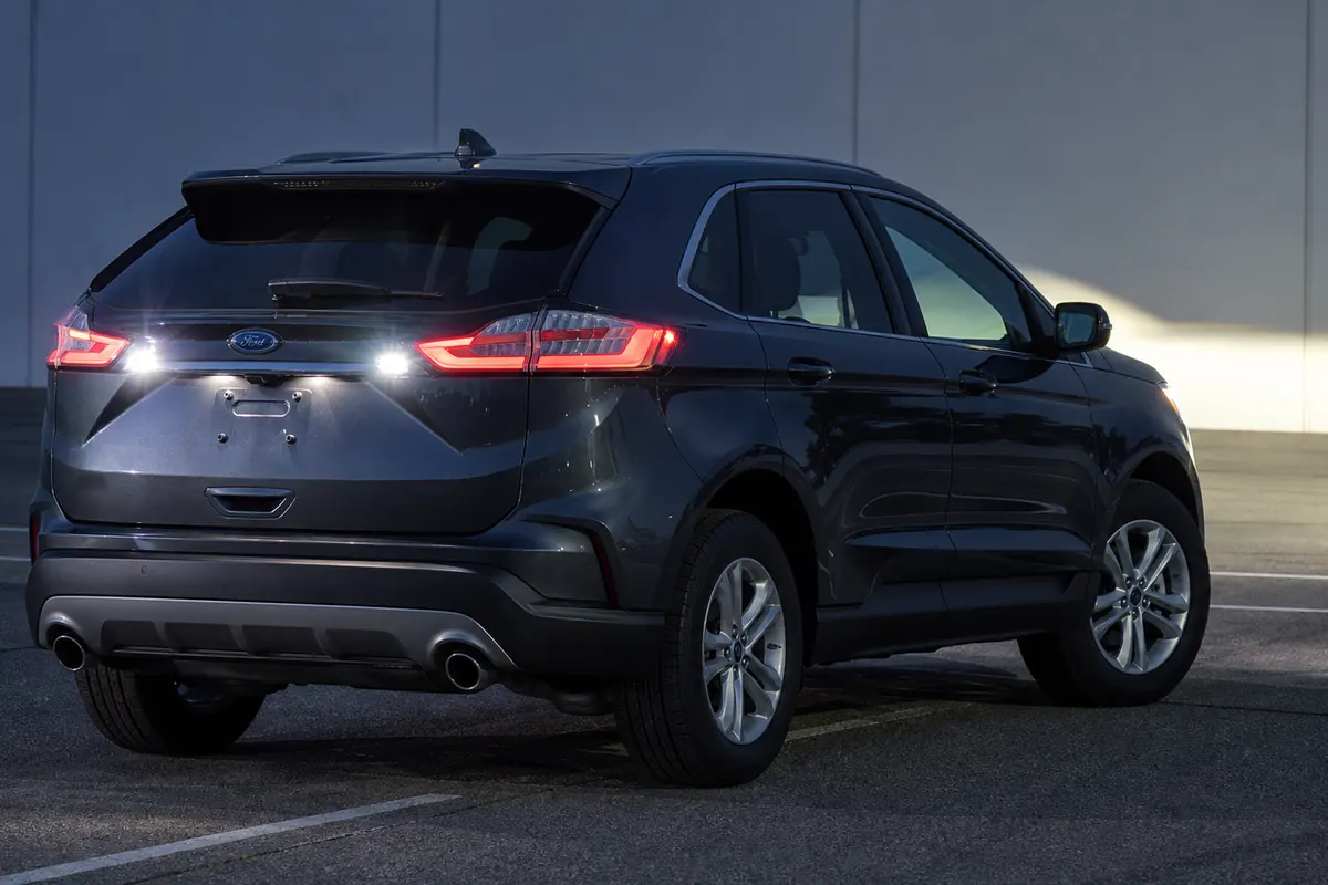 Ford Edge reversing at night while the driver checks the rear camera image and exterior lighting