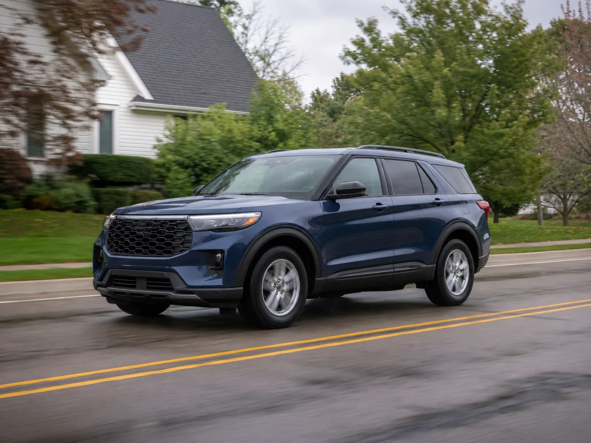 Blue Ford Explorer on a patched suburban road with standard-size wheels