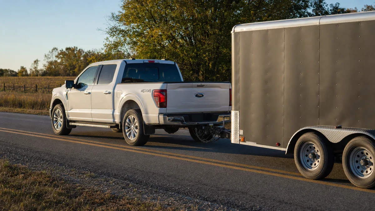 Ford F-150 SuperCrew towing an enclosed trailer on a rural highway