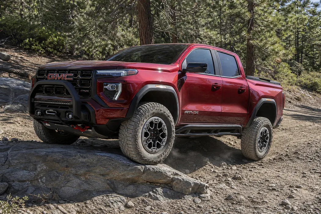 2026 GMC Canyon AT4X placing one front tire on a low rock step - GMC Canyon