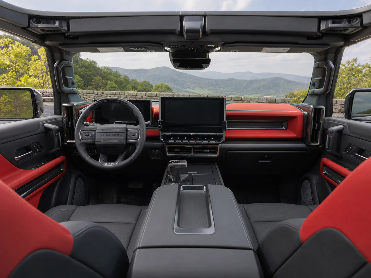 View from the second row across the dashboard, front seats, windshield, and open roof of a GMC Hummer EV - GMC Hummer EV