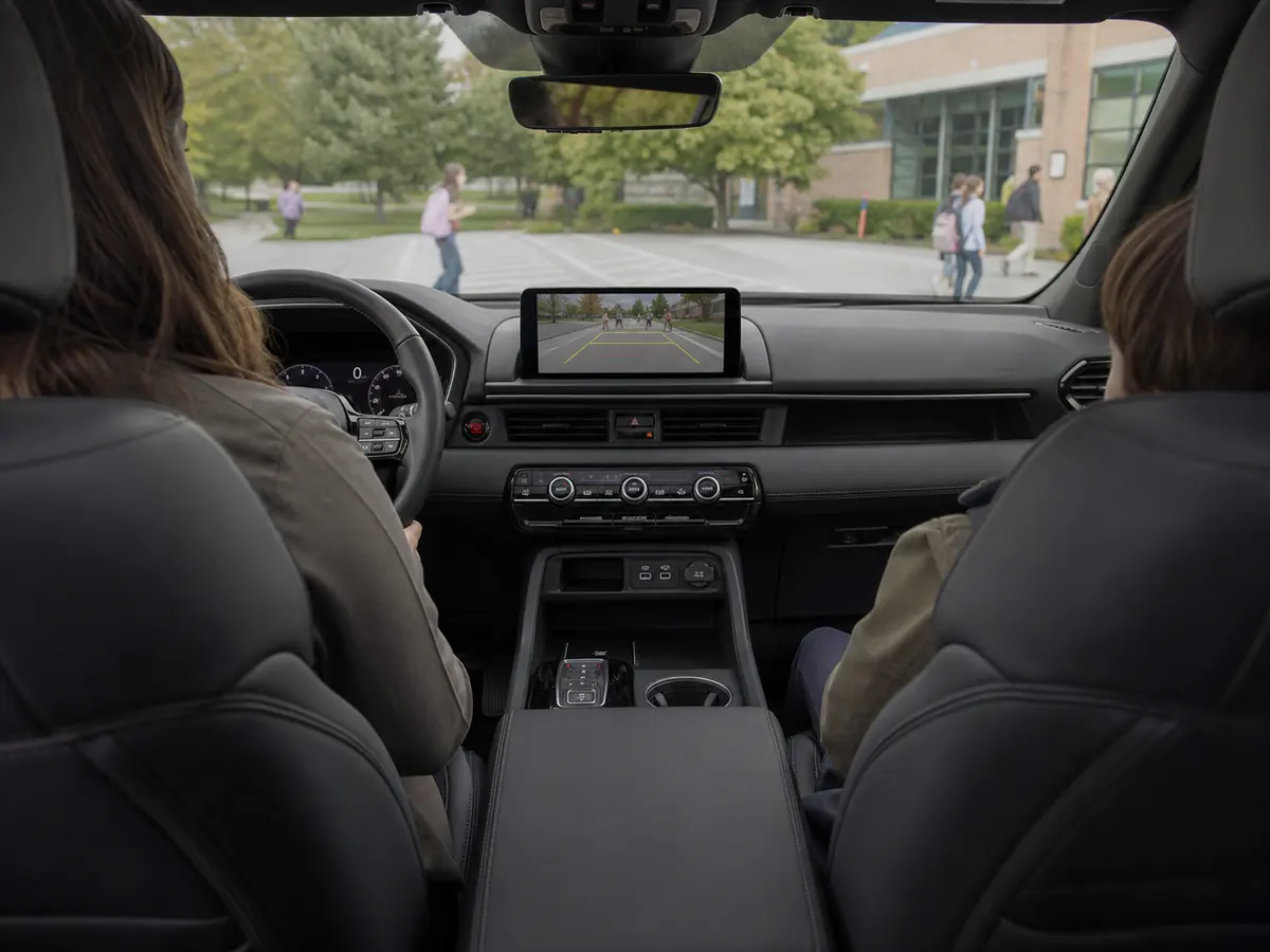 Honda Pilot cabin viewed from the second row with the rear-camera image displayed during school pickup