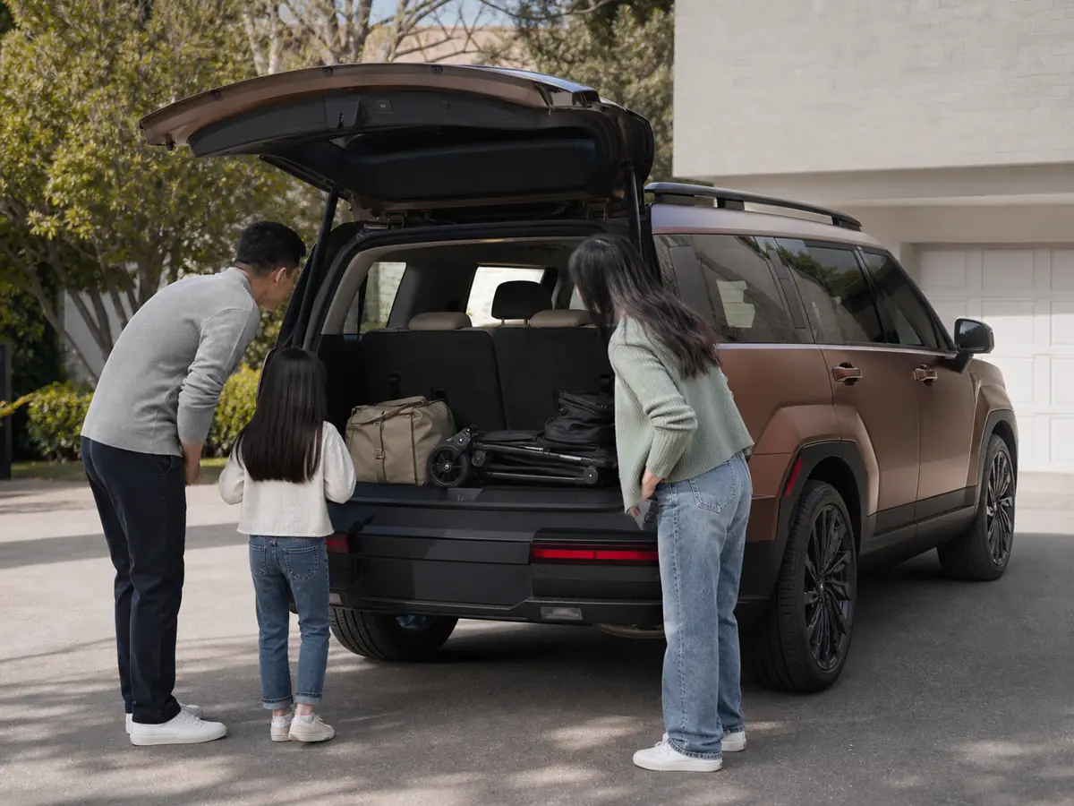 Family loading luggage behind the raised third row of a Hyundai Santa Fe