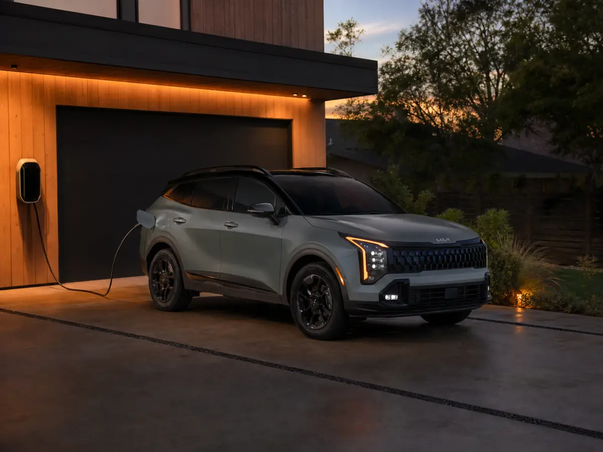 Kia Sportage Plug-in Hybrid charging beside a home parking space