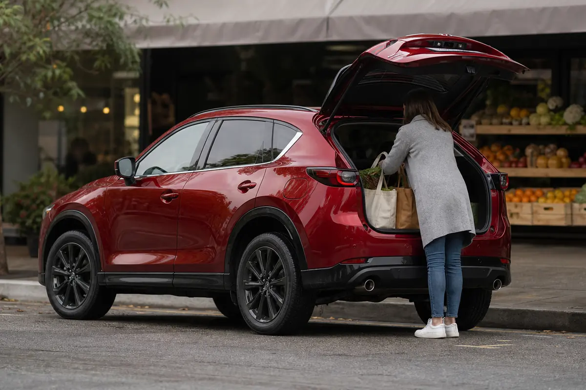 Mazda CX-5 in side-rear view while groceries are loaded at a neighborhood market