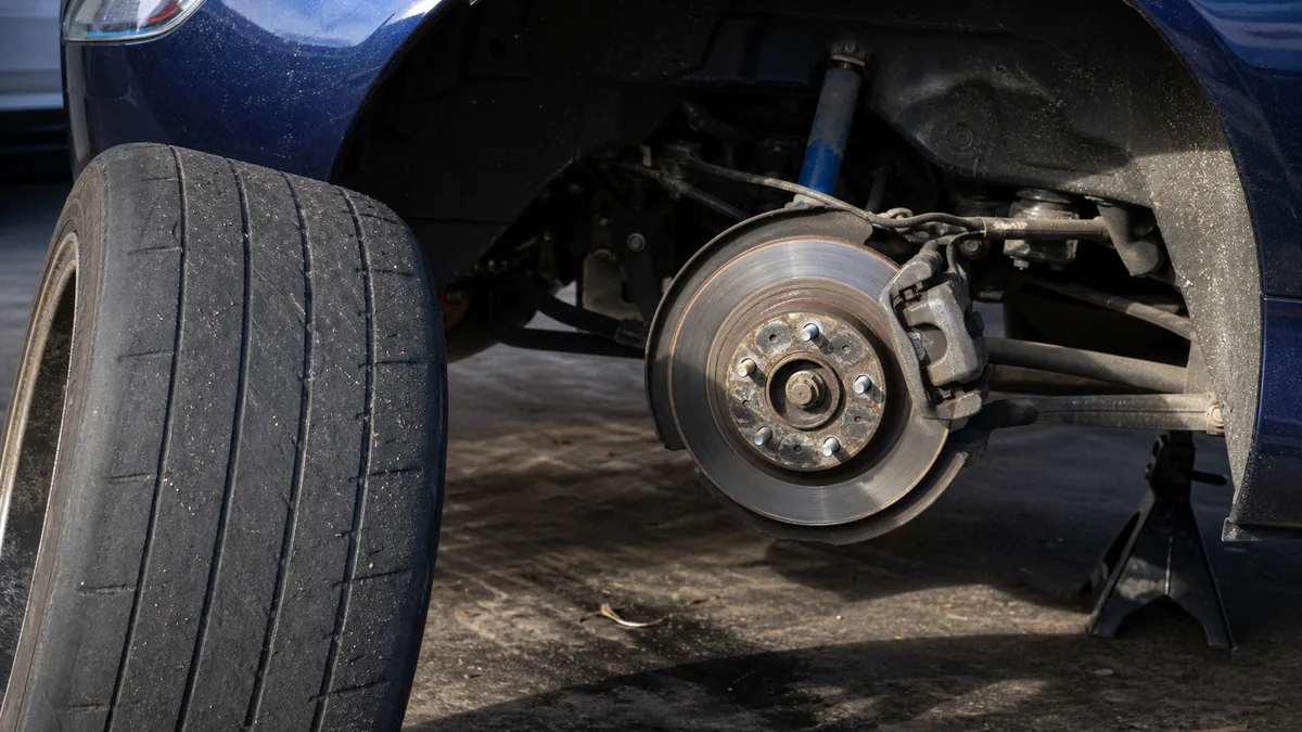 Sports car tire and brake inspection in a garage