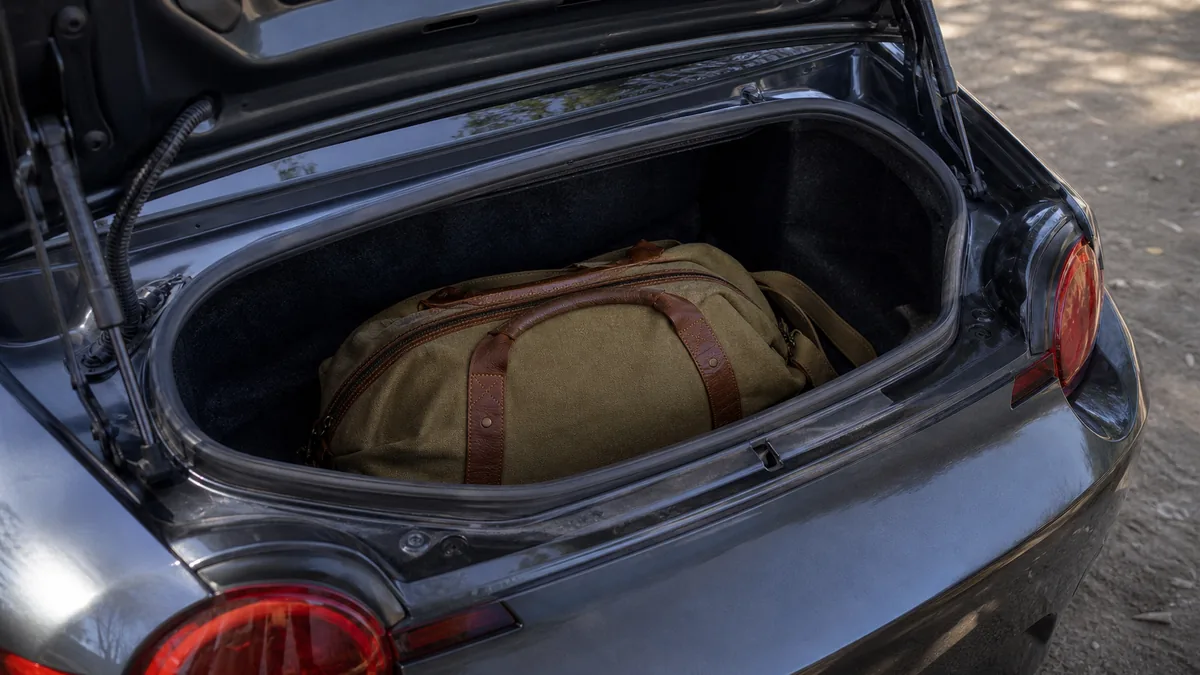 Small roadster trunk packed with an overnight bag