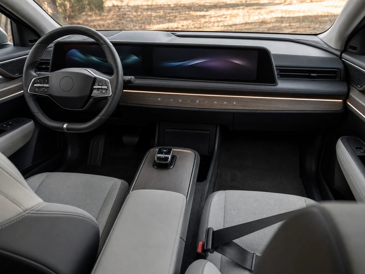 Nissan Ariya front cabin showing dual 12.3-inch displays, the wood-look centre panel and the flat floor - Nissan Ariya