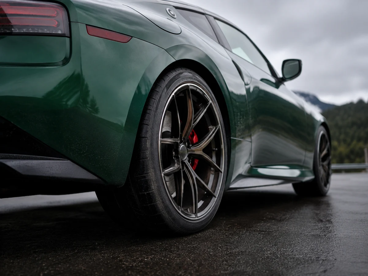 Forged nineteen-inch wheel and wide performance tyre at the rear arch of a Nissan Z, photographed from low behind - Nissan Z