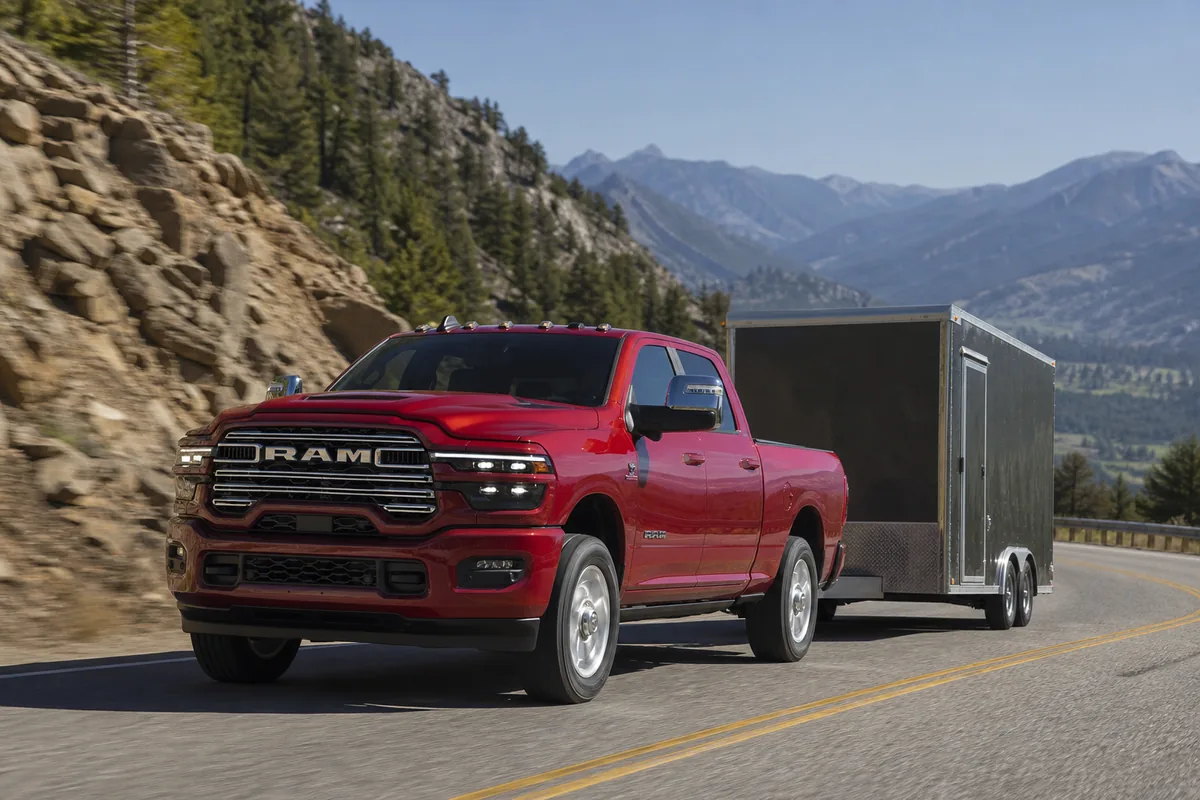2027 Ram 2500 SRW towing a moderate enclosed work trailer on a paved grade