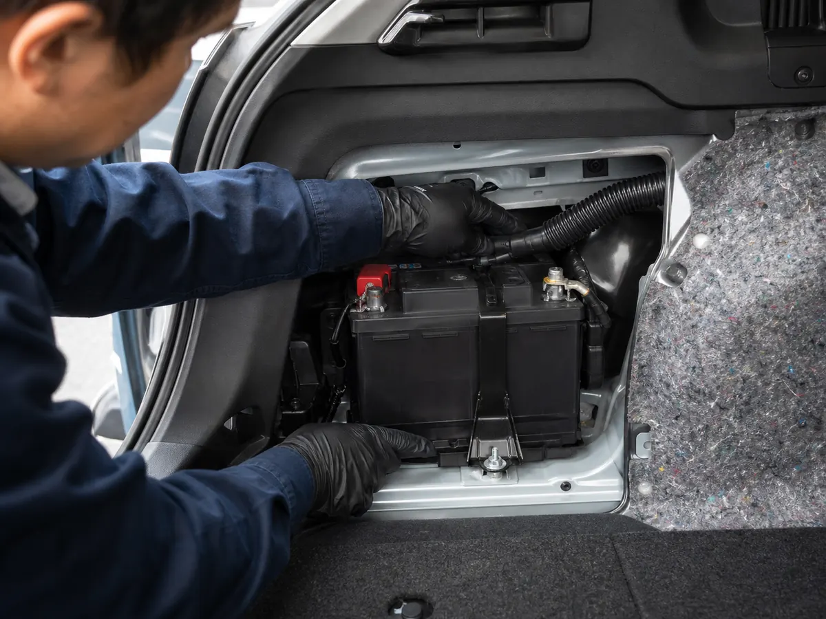 Auxiliary battery vent connection and case label being inspected - Toyota Camry Hybrid battery