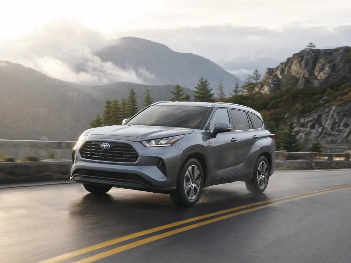 2026 Toyota Highlander Hybrid driving on a damp mountain road - Toyota Highlander Hybrid