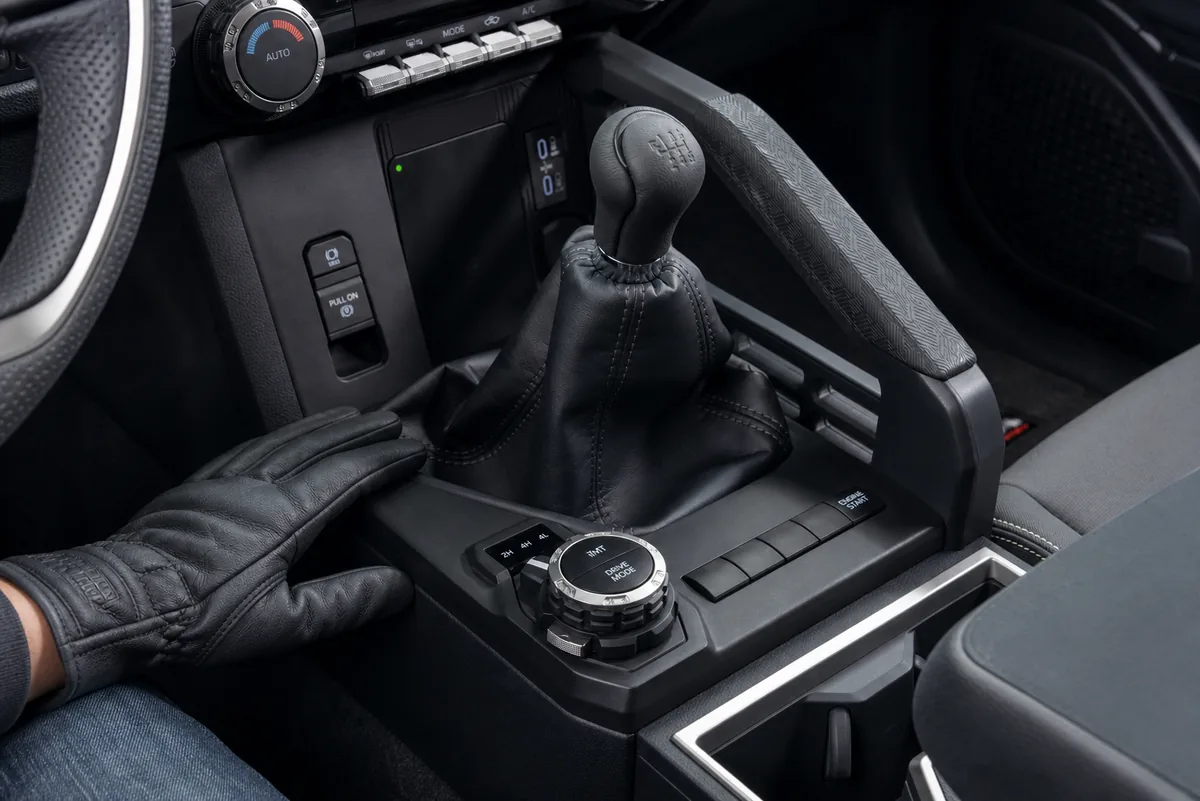 Driver testing clutch take-up and low-speed control in a Toyota Tacoma manual on a graded dirt road - Toyota Tacoma